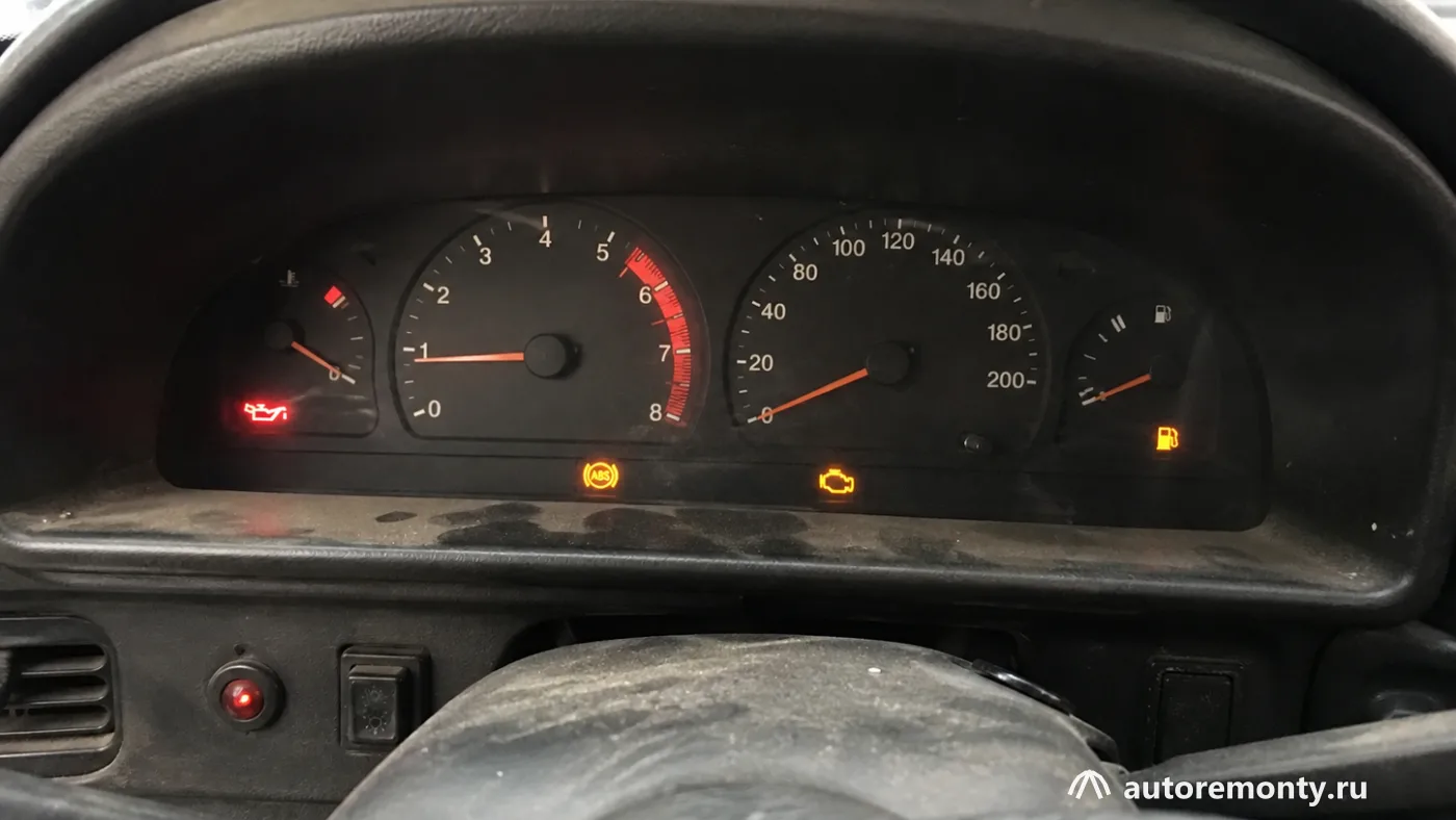 Салон старого бюджетного автомобиля с включённой панелью приборов, в кадре видны индикаторы ABS — какую машину купить до 100 000 рублей 2026