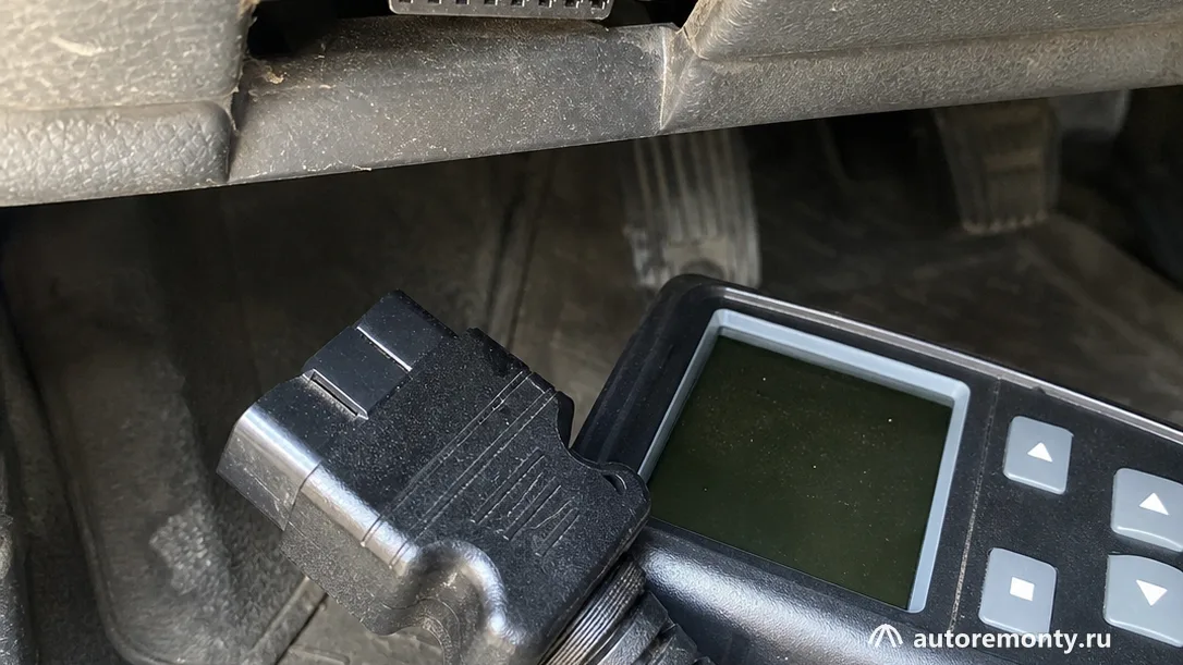 Диагностического разъёма OBD-II под панелью автомобиля, рядом лежит сканер, салон и марка машины не видны — какую машину купить до 800 000 рублей 2026