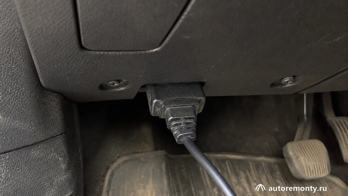 Диагностический разъём Ford Focus 3 с подключённым сканером, в кадре видны только разъём, кабель и — регламент ТО Форд Фокус 3