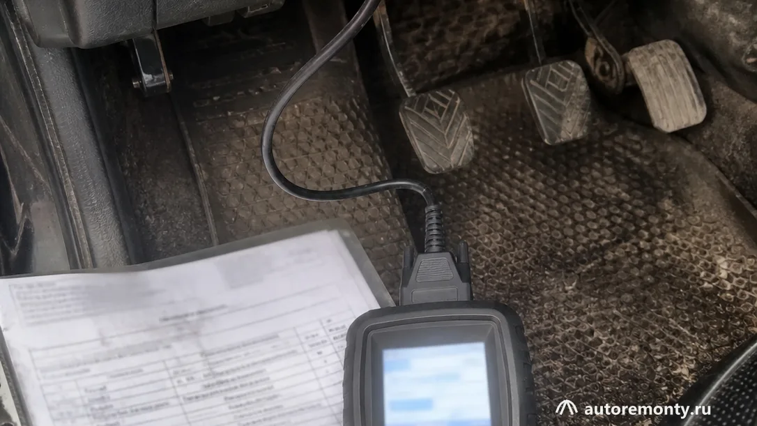 Диагностический прибор, подключённый к разъёму автомобиля, рядом с документами на гарантийное обращение — завод закрылся запчасти