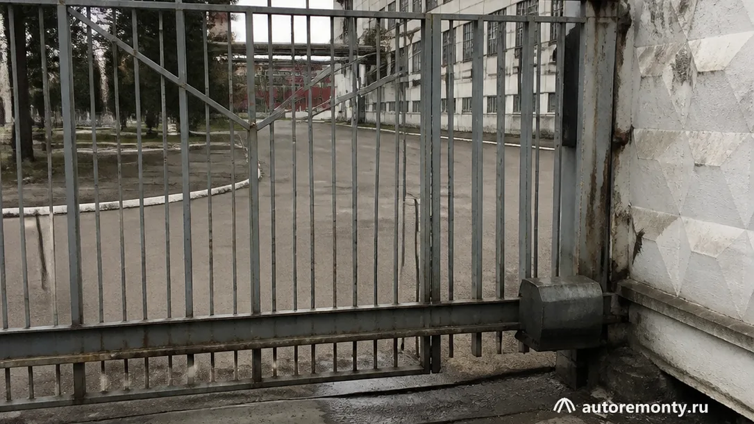 Закрытые ворота автомобильного завода с нейтральной композицией, без логотипов, читаемых надписей и людей — завод закрылся запчасти